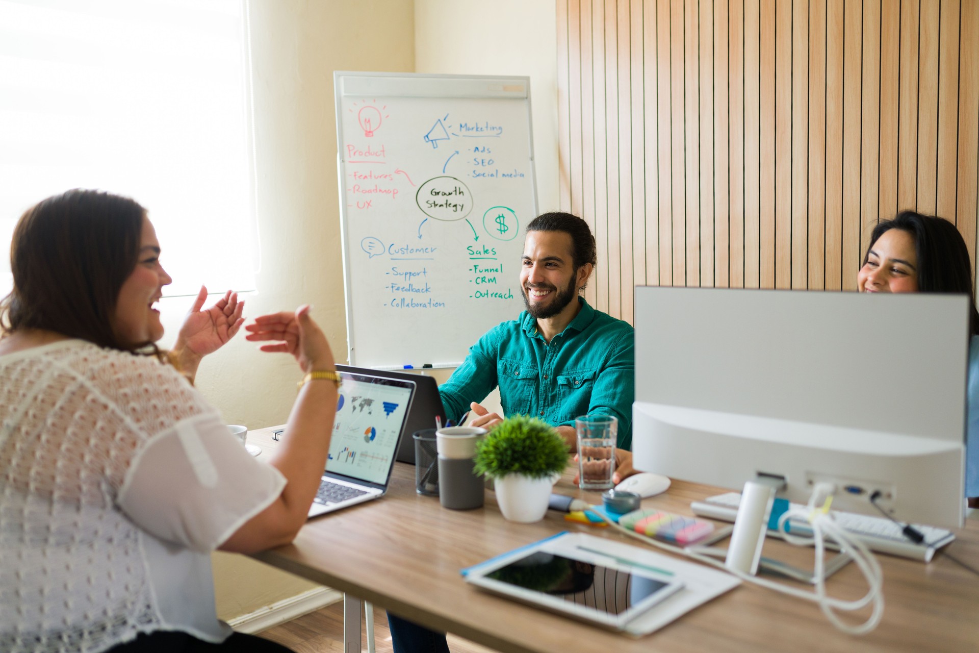 Hispanic coworkers having fun during a team meeting in a startup office